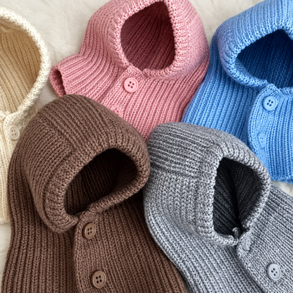 Knitted dog head covers in brown, grey, blue, pink and cream, with button fronts